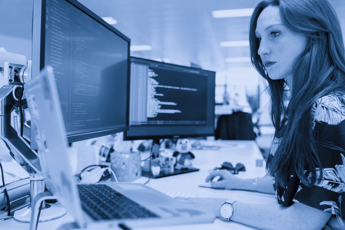 Analista de datos trabajando con múltiples pantallas de información